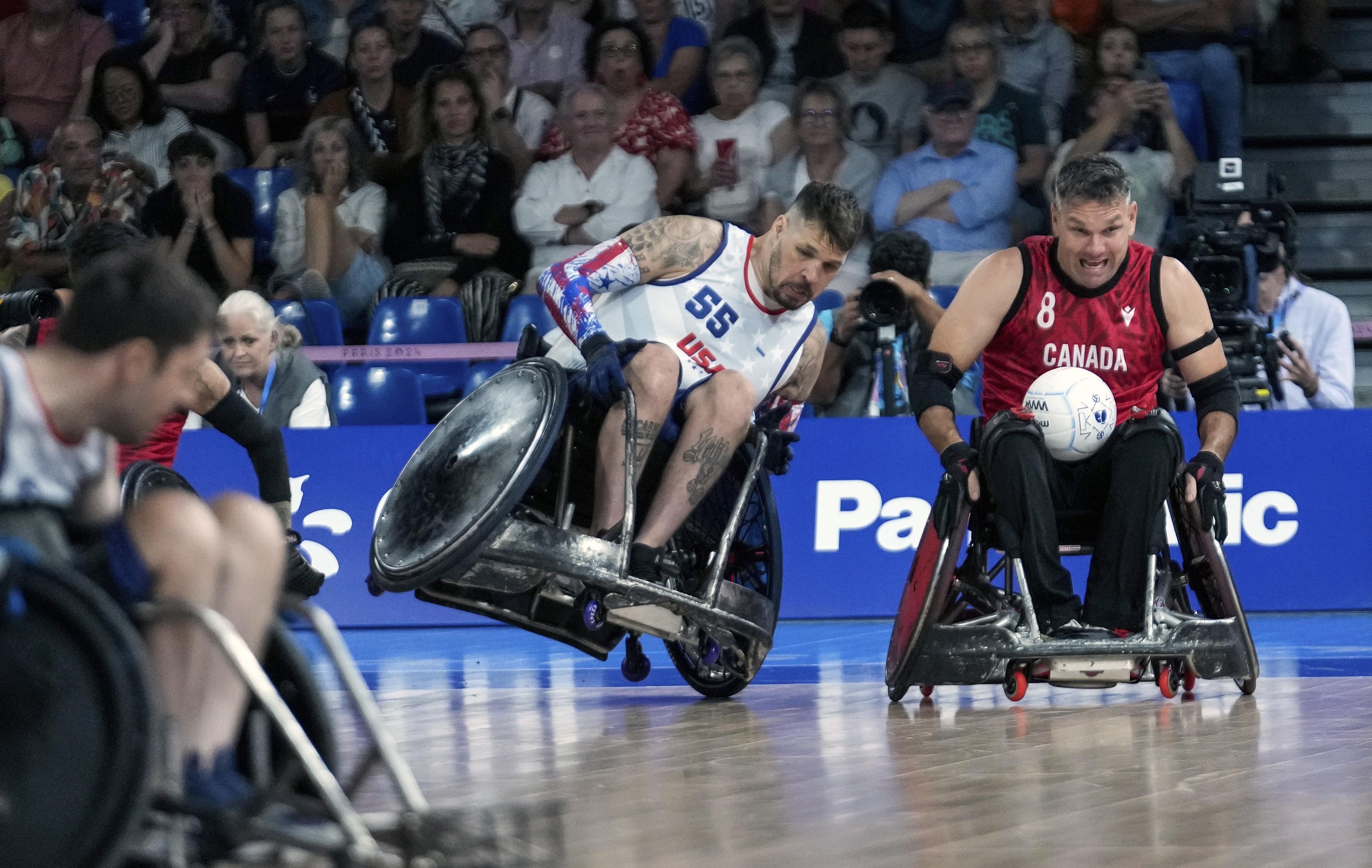 Two wheelchair rugby competitors vie for a ball during a match at the Paralympic Games 