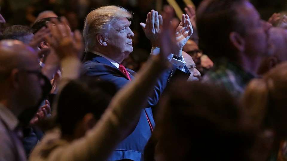 Donald Trump, standing among a group of churchgoers, claps during a worship service in Las Vegas.