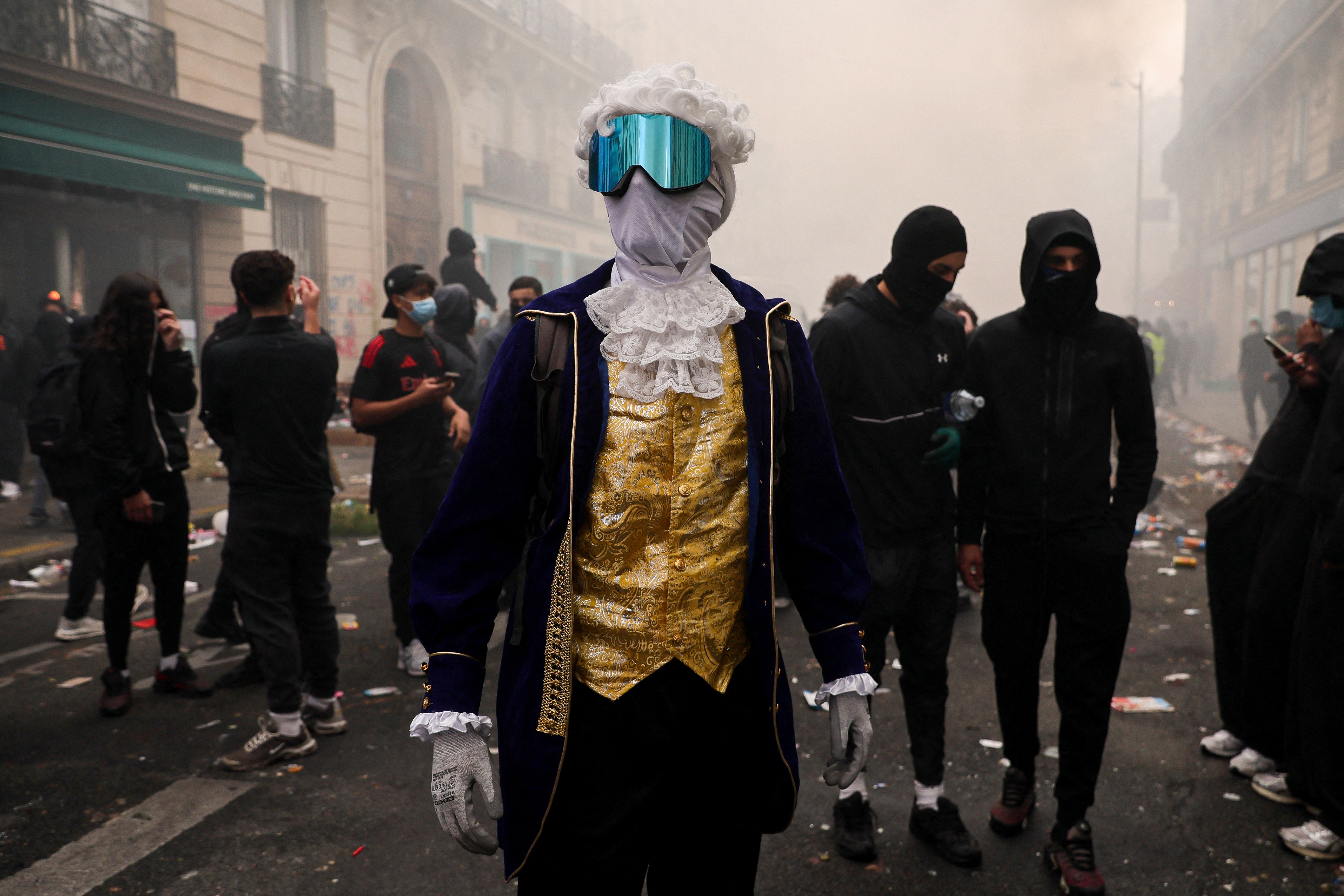 A protester wearing a mask, goggles, and period costume stands during a demonstration in Paris.