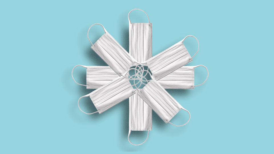 White surgical masks arranged in the shape of a snowflake
