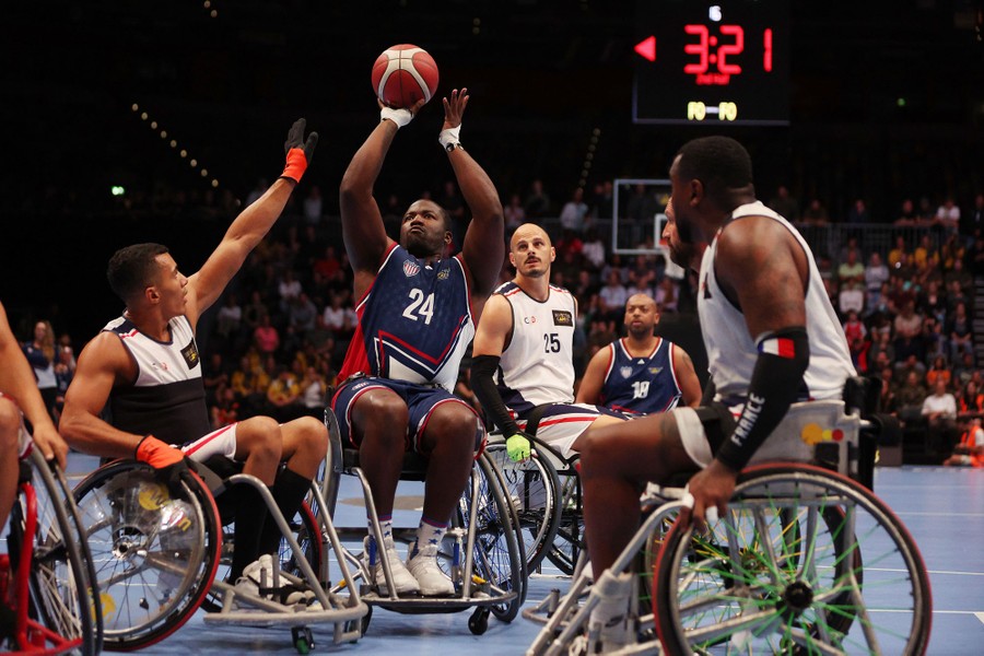 Athletes in wheelchairs play a basketball game.