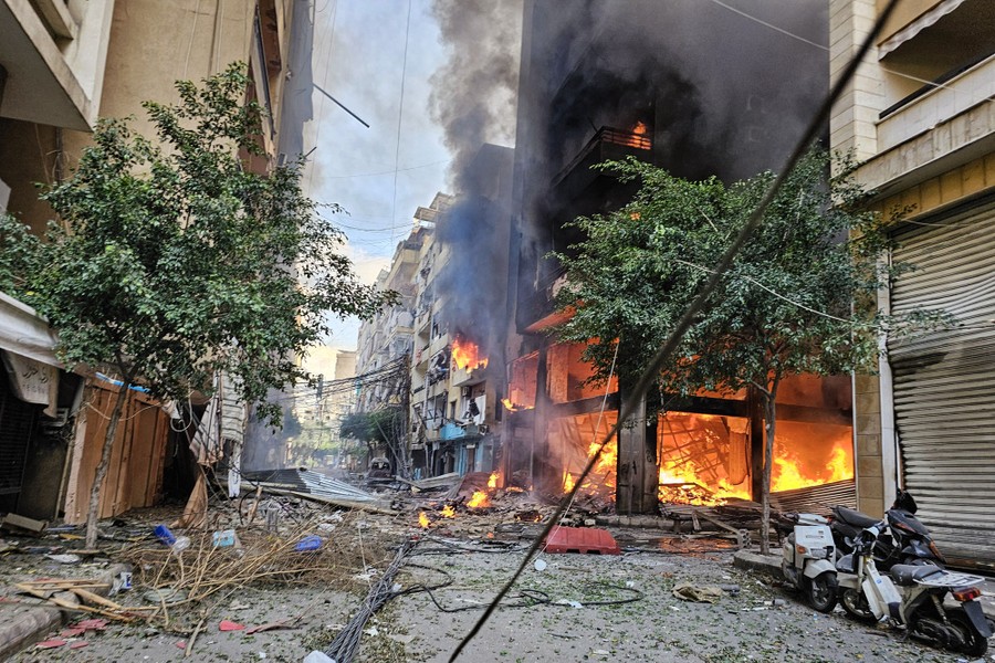 Fire burns inside several tall buildings in a city after a missile strike.