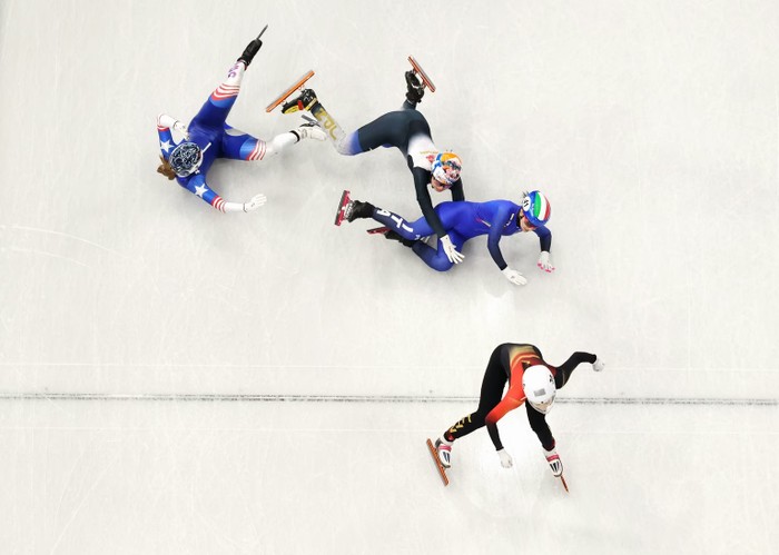 Corinne Stoddard of Team USA, Rika Kanai of Team Japan, and Arianna Sighel of Team Italy crash as Team China's Wang Xinran crosses the finish line in the women's short-track speed-skating 500-meter race in the Winter Olympics.
