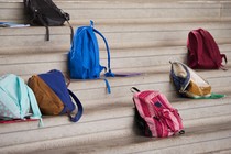 Different colored backpacks scattered on the bleachers