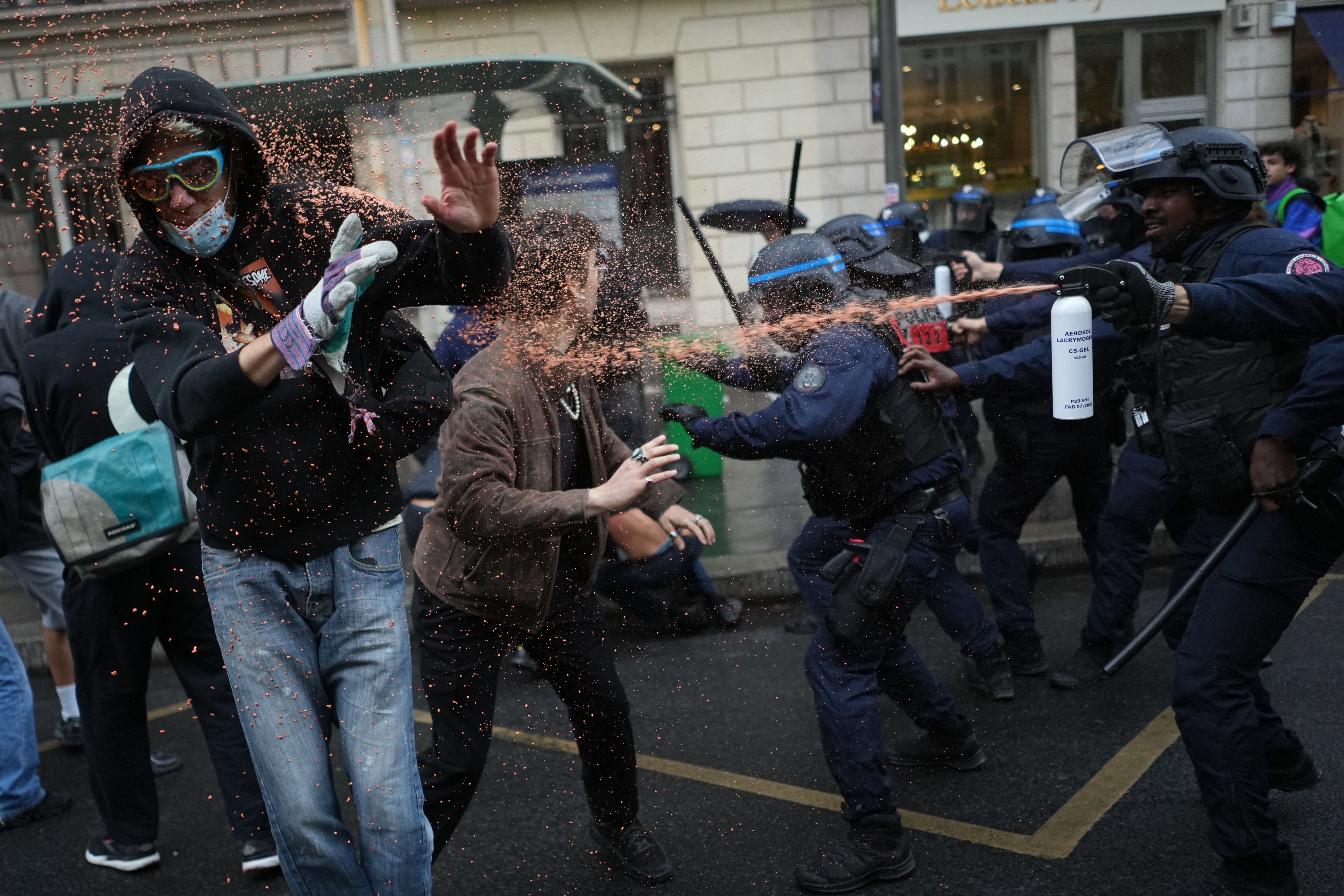 Police officers spray protesting students with pepper spray.