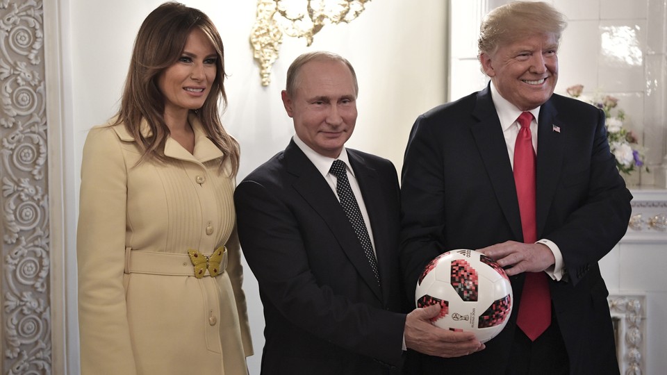 Melania Trump, Vladimir Putin, and Donald Trump pose with a soccer ball.