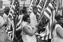 A photo of Black protesters carrying American flags