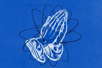 Praying hands over a drawing of an atom