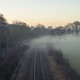 A photo of train tracks shrouded in fog