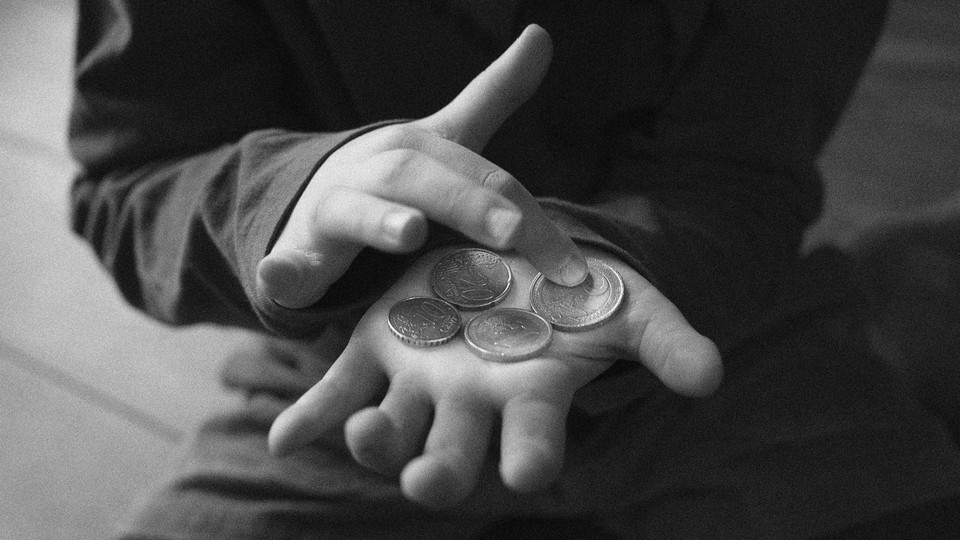 Close-up photo of a child holding coins in their hands