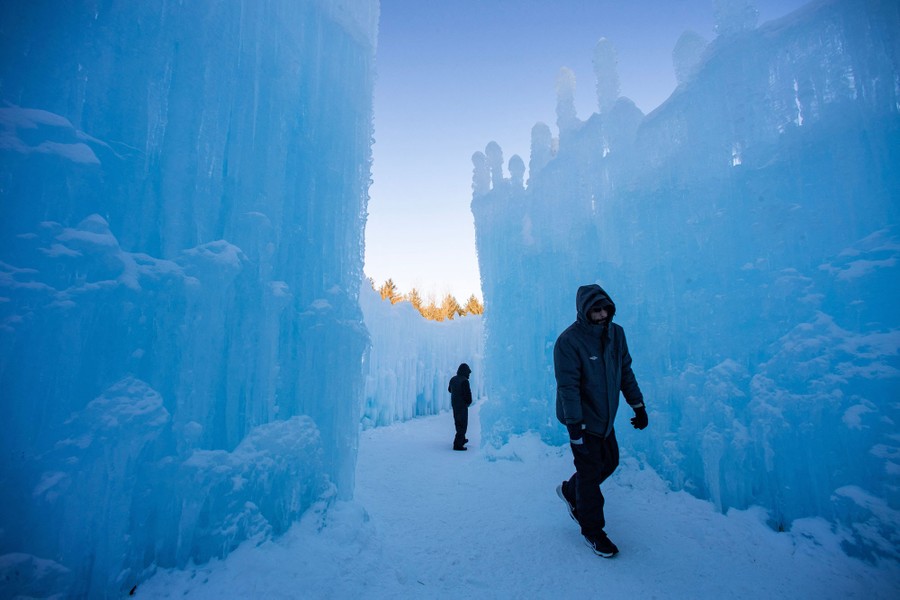 Two people walk among walls made of ice.