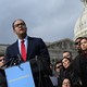 Representative Will Hurd of Texas stands at a podium outside the U.S. Capitol in Washington, D.C. Behind him are 10 men and women watching him speak. The Capitol dome is visible in the background.