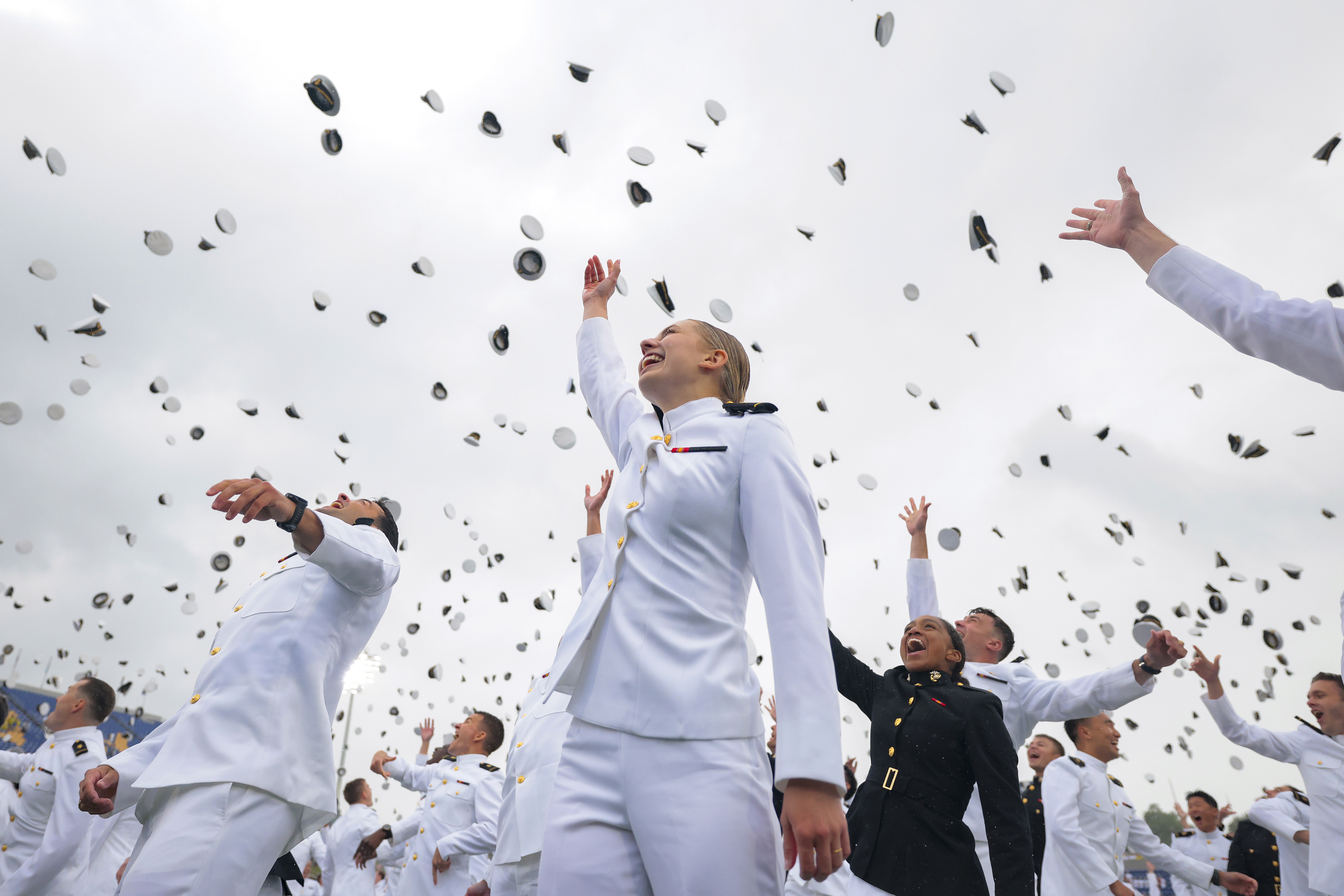 U.S. Naval Academy graduates celebrate with a cap toss during a graduation ceremony.