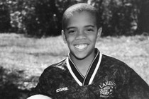Writer Clint Smith, as a child, holding a soccer ball and grinning while wearing a jersey