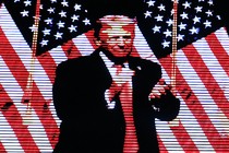 Trump standing in front of two American flags
