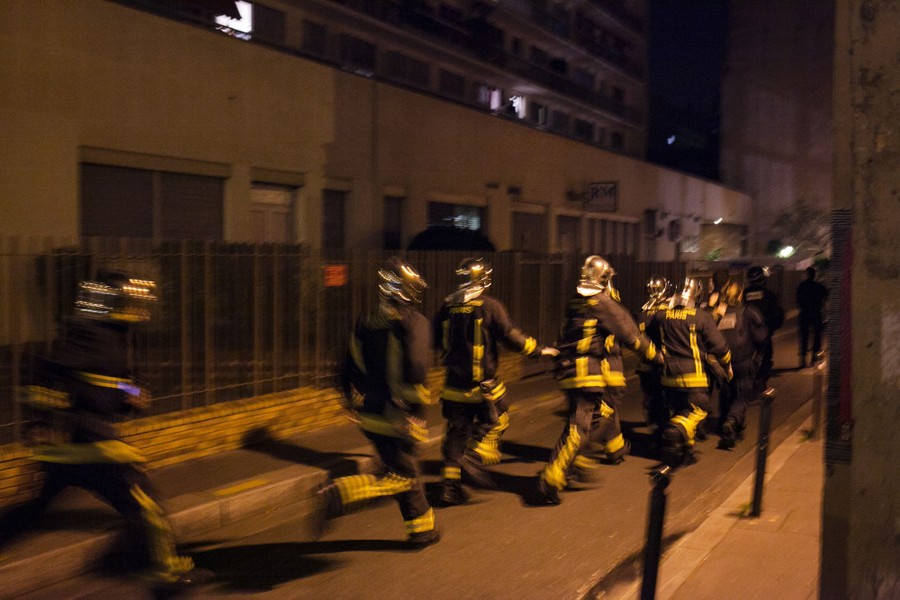 A blurry image of a line of running firefighters in a street