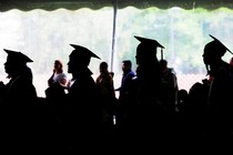 Female college graduates stand in a line. 