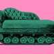 green couch on tank wheels against a pink background