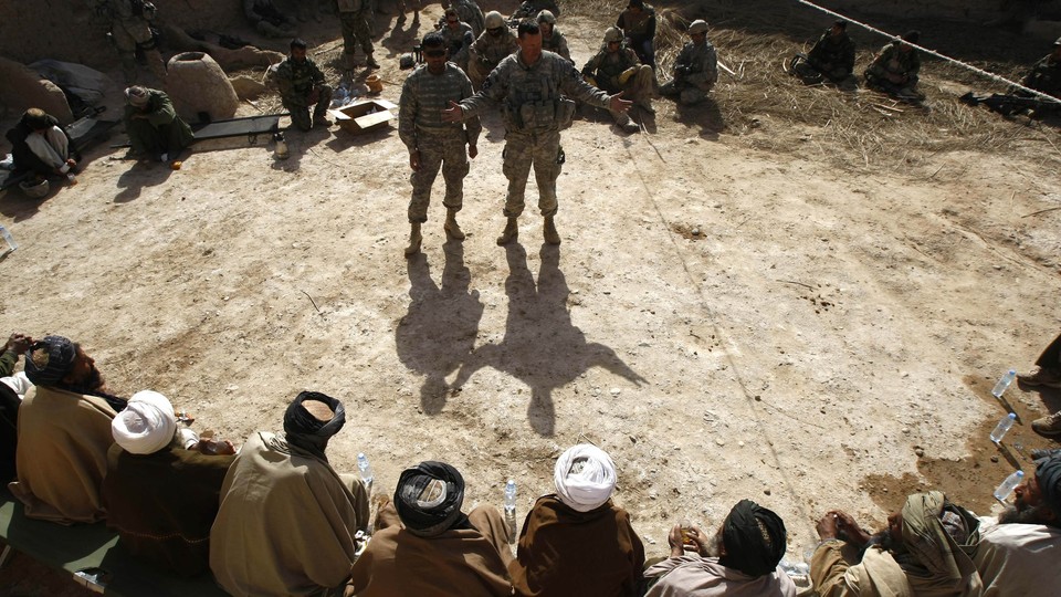 Interpreters being addressed by two soldiers in Afghanistan