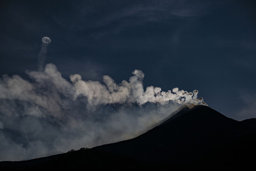 Steam rises from the top of a volcano, forming rings in several places.