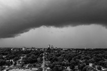 photo of storm clouds over a city with lots of trees