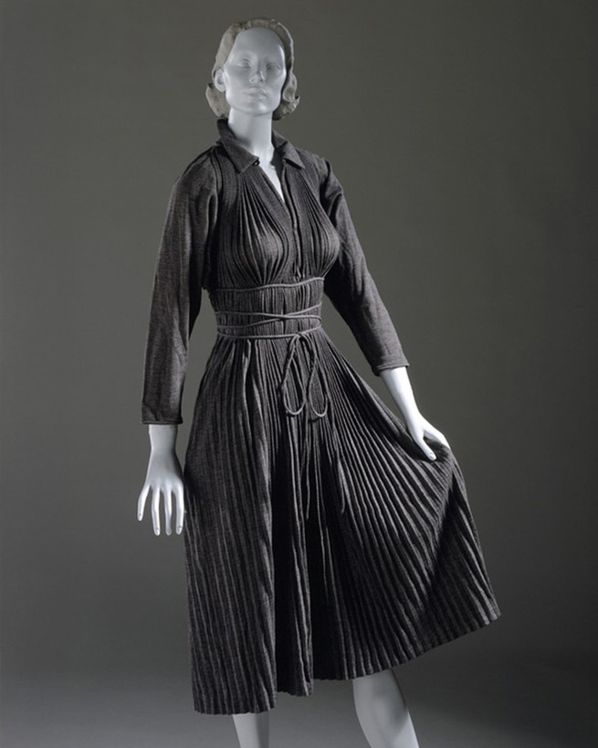 a mannequin in a black "monastic dress" and red heels