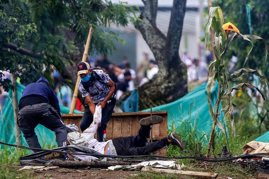 A wounded demonstrator is pulled to safety.