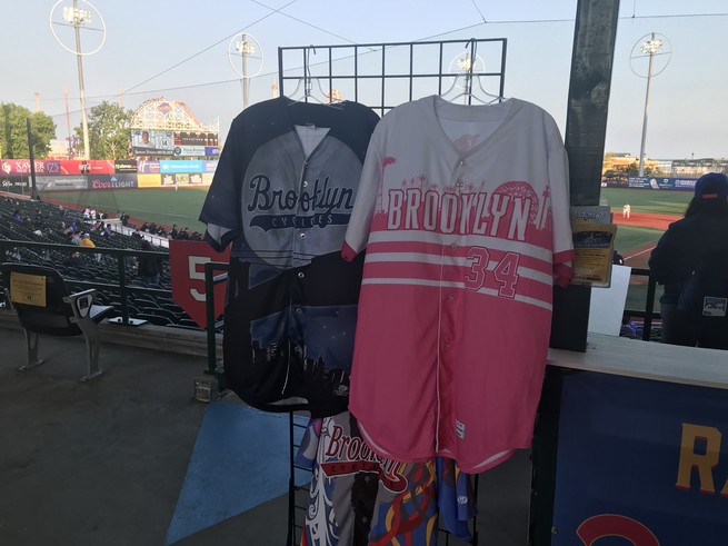 Two Brooklyn Cyclones jerseys—one blue, one pink, on display.