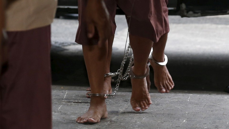 The legs of suspected human traffickers as they arrive for their trial in Bangkok on March 15, 2016