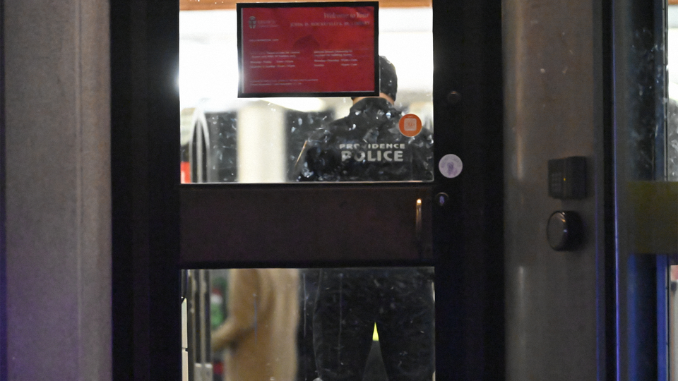 A Providence Police officer, framed by a doorway