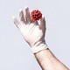 A white gloved hand holds a COVID-19 virus