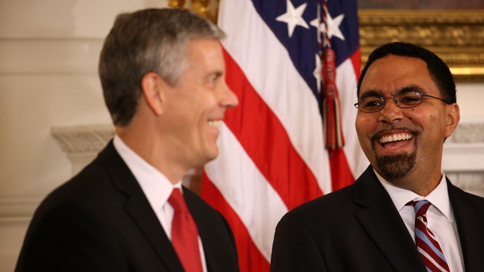 Arne Duncan and John King smile at one another