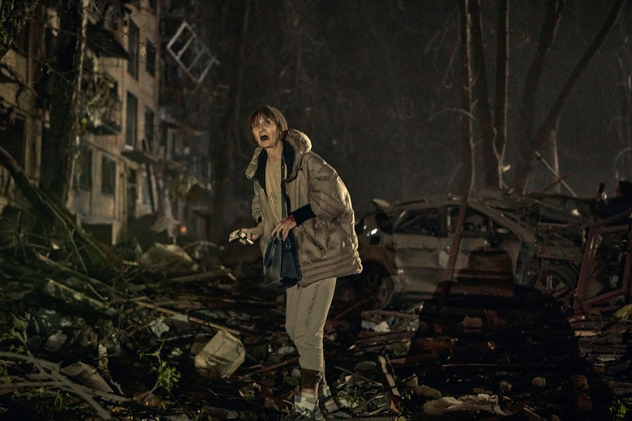 A person appears to call out as they walk through piles of rubble following a missile strike.