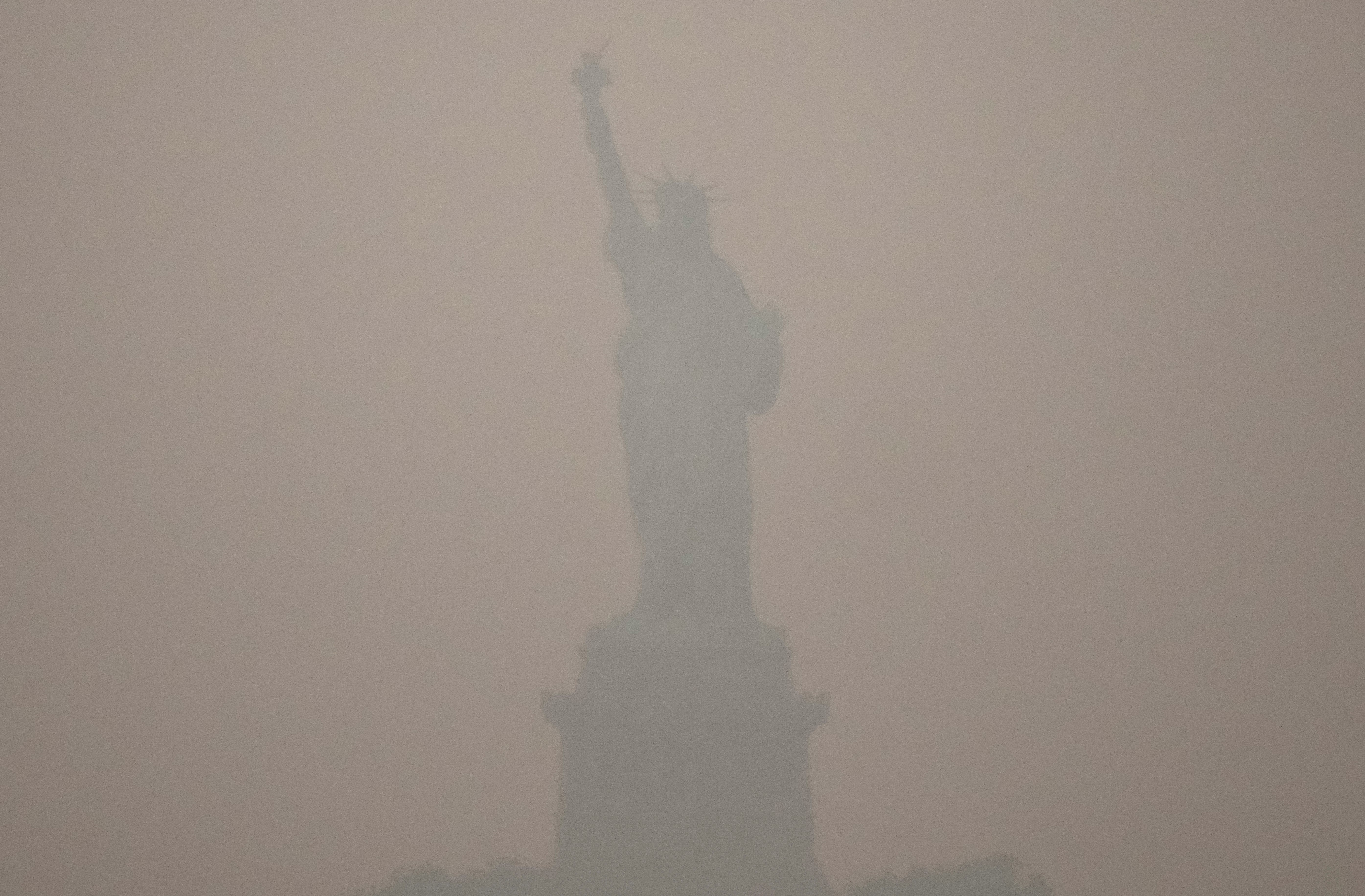 The Statue of Liberty, obscured by thick smoke in the air.