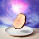 Picture of a piece of meat floating above a table with a purple background behind it