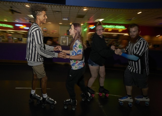 young adult rink workers skate as couples
