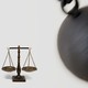 An image of a wrecking ball about to hit the scales of justice