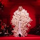 A model wearing a long coat made of stuffed animals walks down a runway.