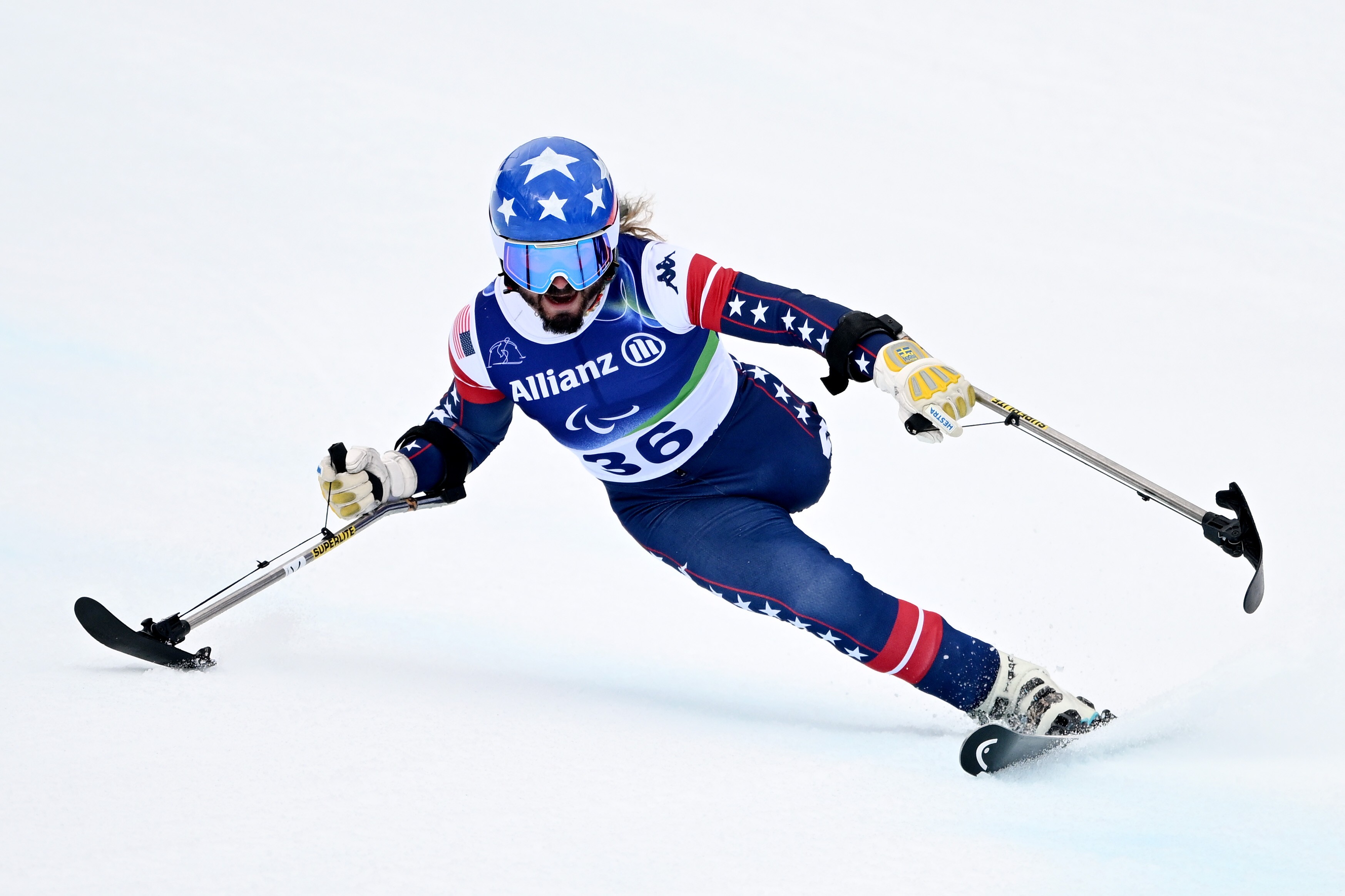 A para-alpine skier using outrigger skis leans and makes a tight turn.