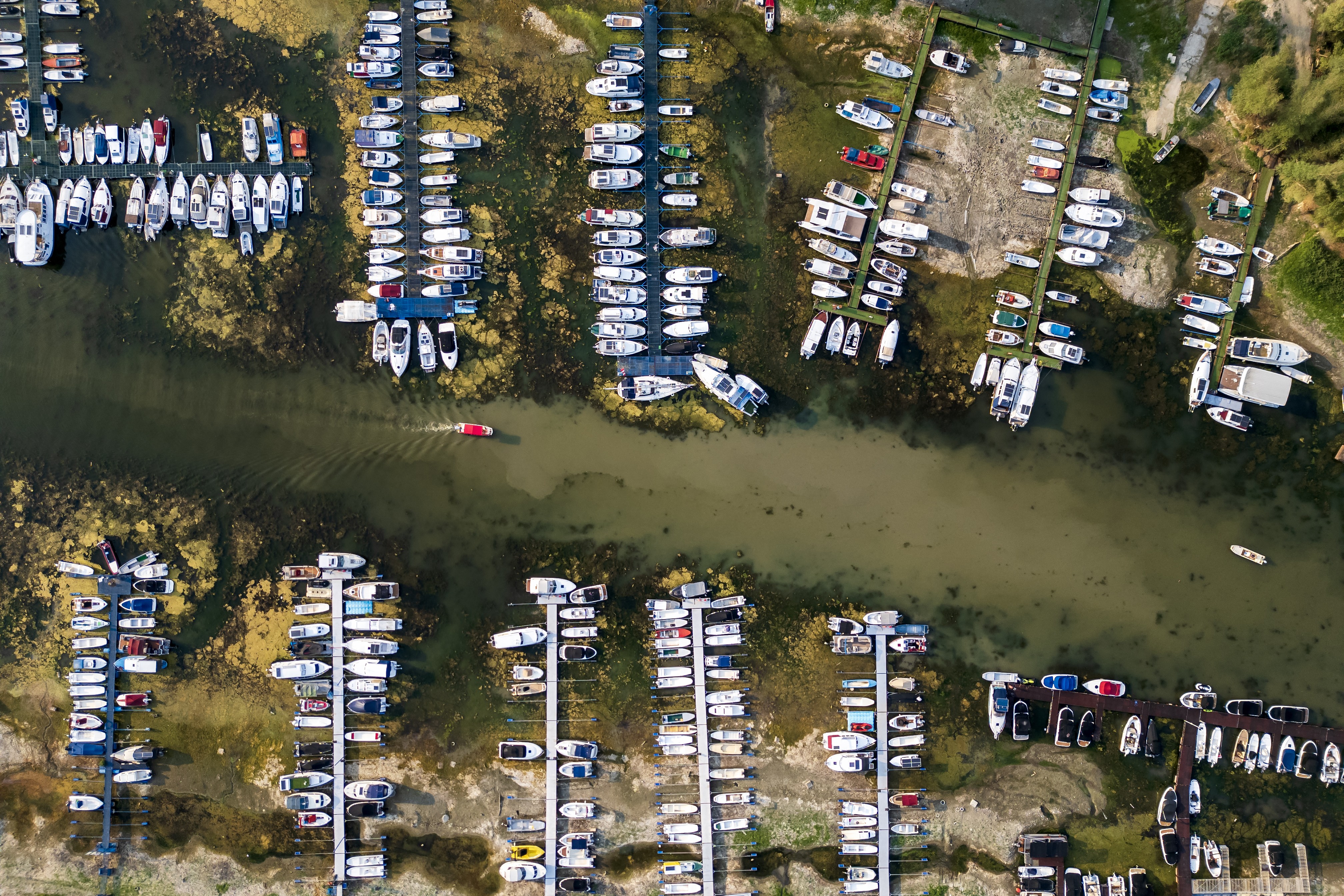 An aerial photo shows boats in a marina left stranded on a dry riverbed.