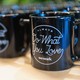 A row of coffee mugs imprinted 'Always Do What You Love  — WeWork'