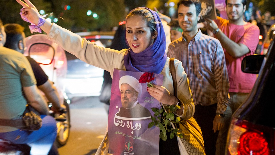 Woman holds a poster of Iranian President Hassan Rouhani during a campaign rally in Tehran.