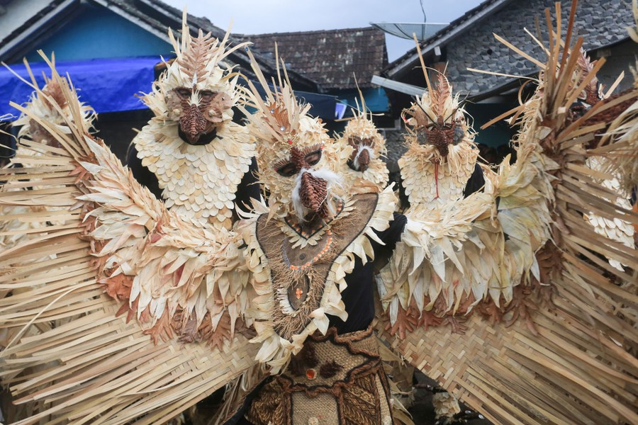 Several performers pose, all wearing birdlike costumes.