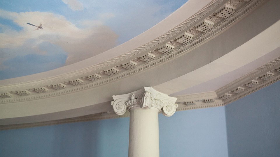 Close-up of a column holding up a ceiling painted to look like the sky