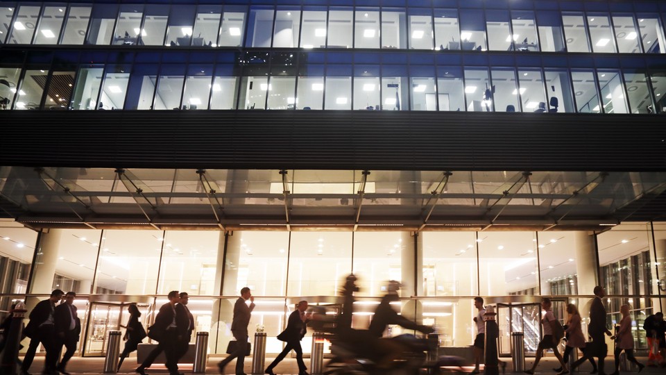 People pass a building at night