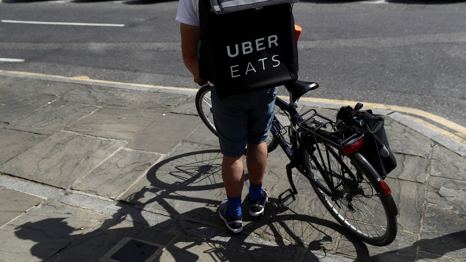 A cyclist prepares to delivery an Uber Eats food order.