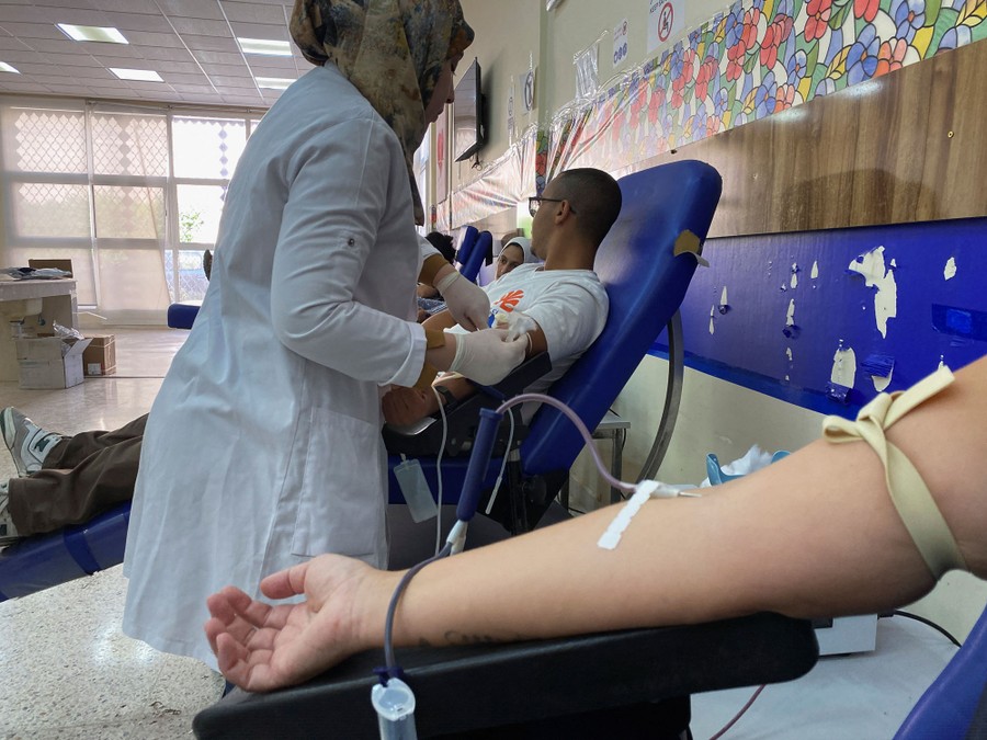 People donate blood, sitting in comfortable chairs in a clinic.