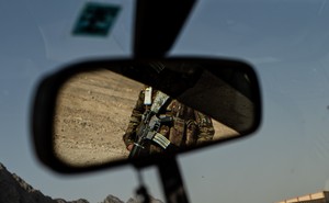 A soldier appears in a rear view mirror