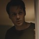 Bill Skarsgård peering around a door in "Barbarian"