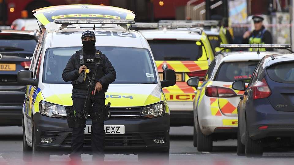 An armed police officer stands in front of a police car in the London Bridge area of the British capital.